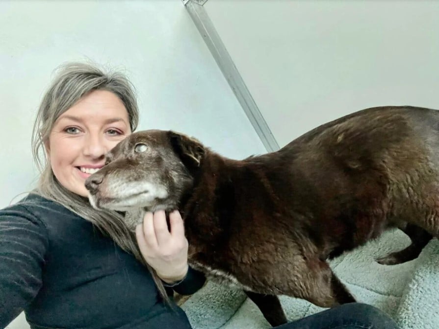 Smiling woman hugging dog