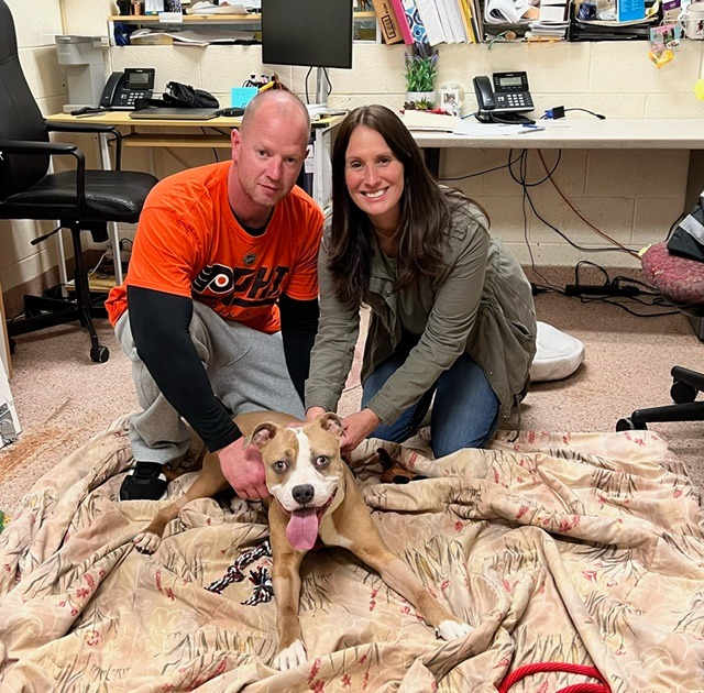 Woman and man posing with happy dog